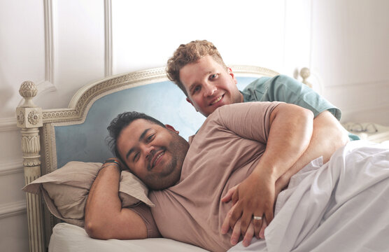 homosexual couple hugs each other in bed