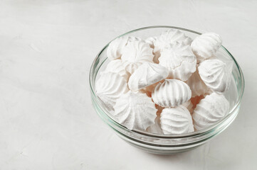 glass vase with French meringue dessert on a gray background, side view, copy space.