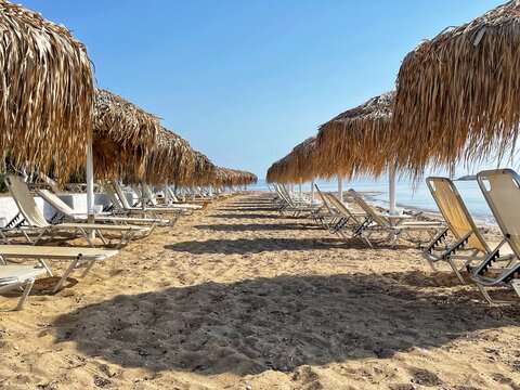 Rows of sun loungers on Aquarius Beach, Skala, Agistri, Attica, Greece