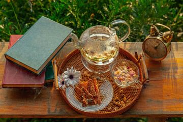 Chrysanthemum tea with hot steam and sweet potato jam, books, alarm clock on wooden table, in the...