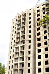 Fototapeta premium Construction of a residential building. Tower cranes building a new residential building. Unfinished panel house and construction crane