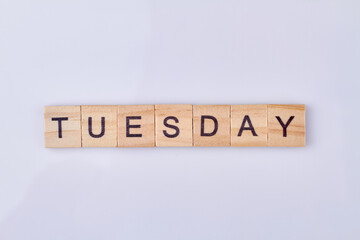Tuesday word written with vintage wooden cubes and black letters. Weekday concept.