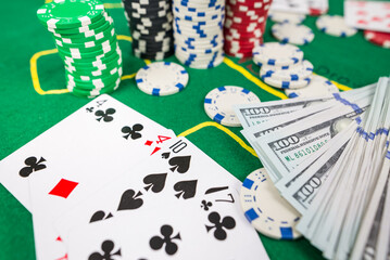 Poker game concept. Poker cards with chips and dollars on a green poker table.