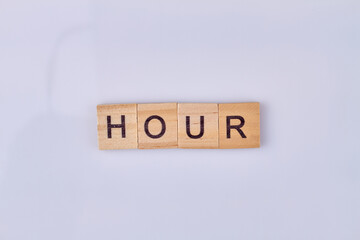 Hour word written on wooden blocks. Isolated on white background. Flat lay.