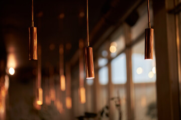 Elongated lamps in the interior of the restaurant. Stylish interior