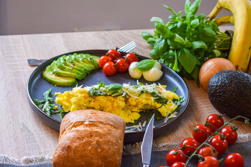 French omelette dish. Delicous homemade french omlette filled with cheese. Plating with fresh vegetables like avocado, cherry tomatoes, but also basil and mozzarella.