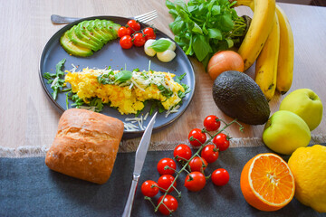 French omelette dish. Delicous homemade french omlette filled with cheese. Plating with fresh vegetables like avocado, cherry tomatoes, but also basil and mozzarella. - obrazy, fototapety, plakaty