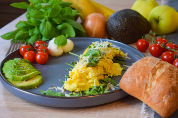 French omelette dish. Delicous homemade french omlette filled with cheese. Plating with fresh vegetables like avocado, cherry tomatoes, but also basil and mozzarella.