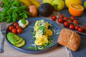 French omelette dish. Delicous homemade french omlette filled with cheese. Plating with fresh vegetables like avocado, cherry tomatoes, but also basil and mozzarella.