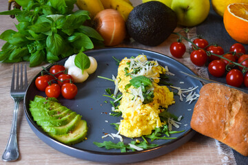 French omelette dish. Delicous homemade french omlette filled with cheese. Plating with fresh vegetables like avocado, cherry tomatoes, but also basil and mozzarella.