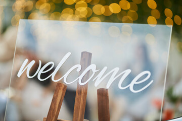 The inscription welcome on a glass signboard on bokeh background 