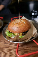 Juicy burger with beef, iceberg lettuce, vegetables and sauce. Appetizing rurger