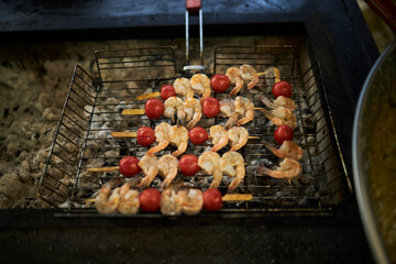 Cherry tomato and shrimp skewers. Grilling process