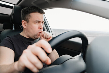 a sleepy and yawning man drives a car on the highway