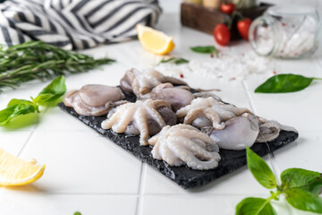 baby octopus. freshly frozen. beautiful serving on a platter. with herbs and spices on a light background