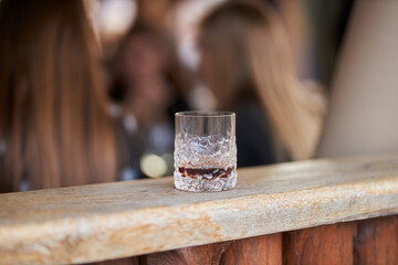 a glass of whiskey stands on a wooden background. glass of whiskey close-up