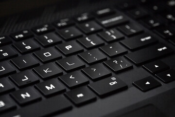 Close-up of computer keyboard, technological black and white background with selective focus