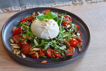 Burrata Salad with Cherry Tomatoes, Rucola, Basil, Olive Oil and Balsamic Creme. Burrata fresh cheeses tastes amazing and can be served alongside tomatoes, grilled bread, or vegetables.
