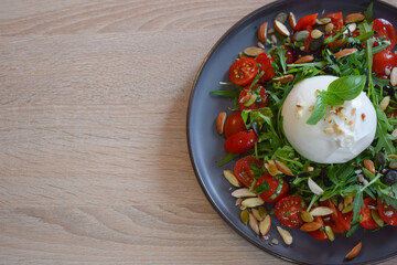 Burrata Salad with Cherry Tomatoes, Rucola, Basil, Olive Oil and Balsamic Creme. Burrata fresh cheeses tastes amazing and can be served alongside tomatoes, grilled bread, or vegetables.