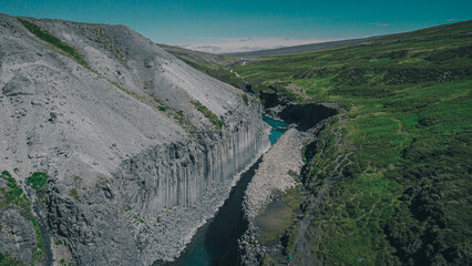Fototapeta na wymiar Aerial drone panorama of studlagil canyon in Iceland, picturesque valley with basalt columns standing high on a warm summer day.