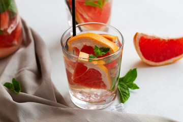 fruit cocktail.Cocktail with grapefruit. Grapefruit lemonade with fresh fruits and green mint in a glass on white background. copy space. Refreshing summer drinks on the table.
