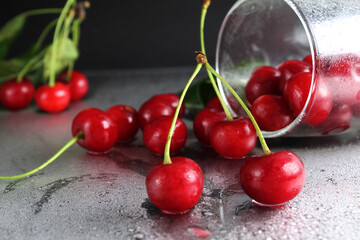 cherry red ripe berry fell out of the glass on a black background with the est for the text. vitamins seasonal berry hemoglobin