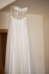 Fototapeta na wymiar Wedding dress hanging on a trempel beautiful wedding dress 