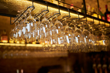 Clean washed glass goblets hang on a hanging shelf
, bar counter 