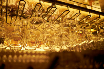 Clean washed glass goblets hang on a hanging shelf
, bar counter 