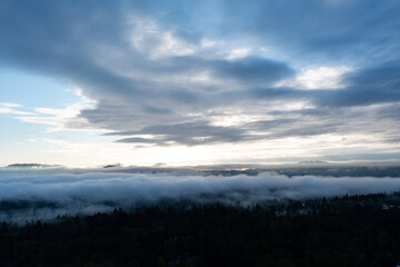 A serene sunrise illuminates low clouds and fog over the Willamette River south of Portland, Oregon. This scenic Pacific Northwest region is known for its moist climate.