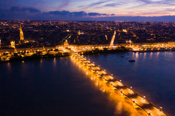 Fototapeta na wymiar Aerial view of Bordeaux cityscape on banks of Garonne river and Pont de pierre at night