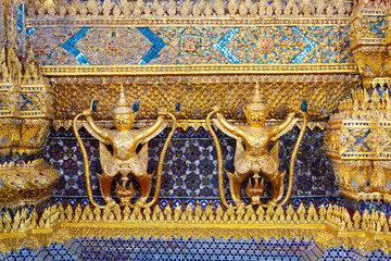 Golden garuda and naga statue, decoration on a wall of The Emerald Buddha temple, Wat Phra Kaew,...