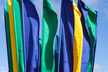 yellow, blue and green flags on the sky background