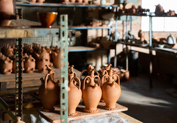 Fototapeta na wymiar Different ceramic products on racks in pottery workshop