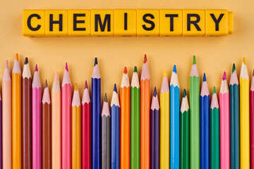 Creative flat lay from multicolored pencils and inscription Chemistry on color background....