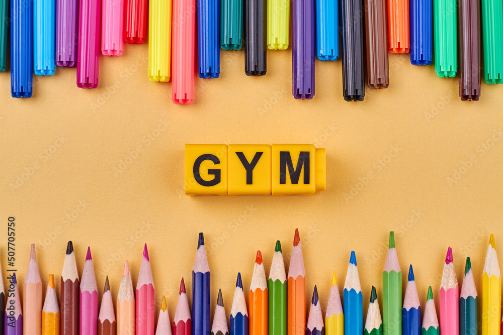 Fototapete gym word written on color cubes in frame from colorful pencils. flat lay composition.