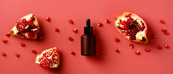Serum with extract of pomegranate on a red background. Vitamin c natural cosmetic product