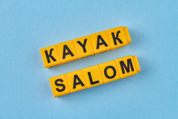 The inscription Kayak Slalom written on yellow cubes against blue background. Extreme water sport concept.