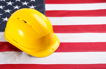 Fototapeta Yellow protective hard hat on American flag. Space for text obraz