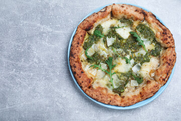 Delicious pizza with pesto, cheese and arugula on grey table, top view. Space for text