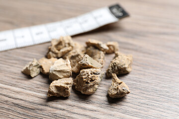 Pile of kidney stones on wooden table, closeup