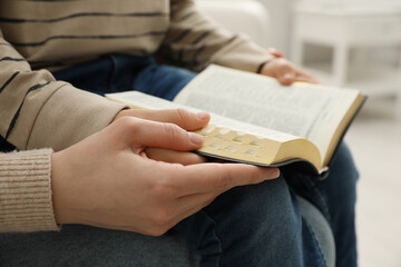 Fototapeta premium Boy and his godparent reading Bible together indoors, closeup