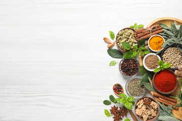 Different fresh herbs and spices on white wooden table, flat lay. Space for text
