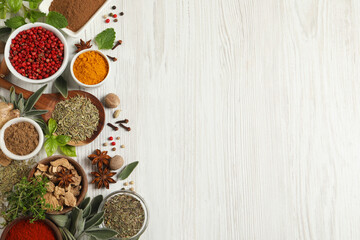 Different fresh herbs and spices on white wooden table, flat lay. Space for text