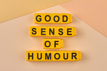 The inscription good sense of humour written on yellow cubes against light background. Flat lay...