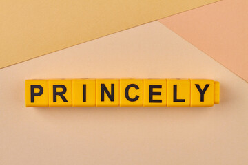 The word princely written on yellow cubes on color background close up. Flat lay.