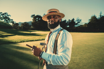 A portrait of a dashing mature bearded black man in a fashionable outfit with a straw hat and...
