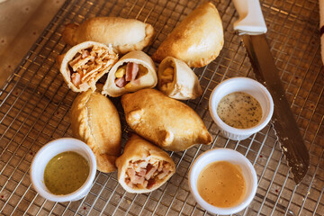 A table with empanadas and sauces