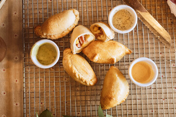 A table with empanadas and sauces