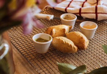 A table with empanadas and sauces